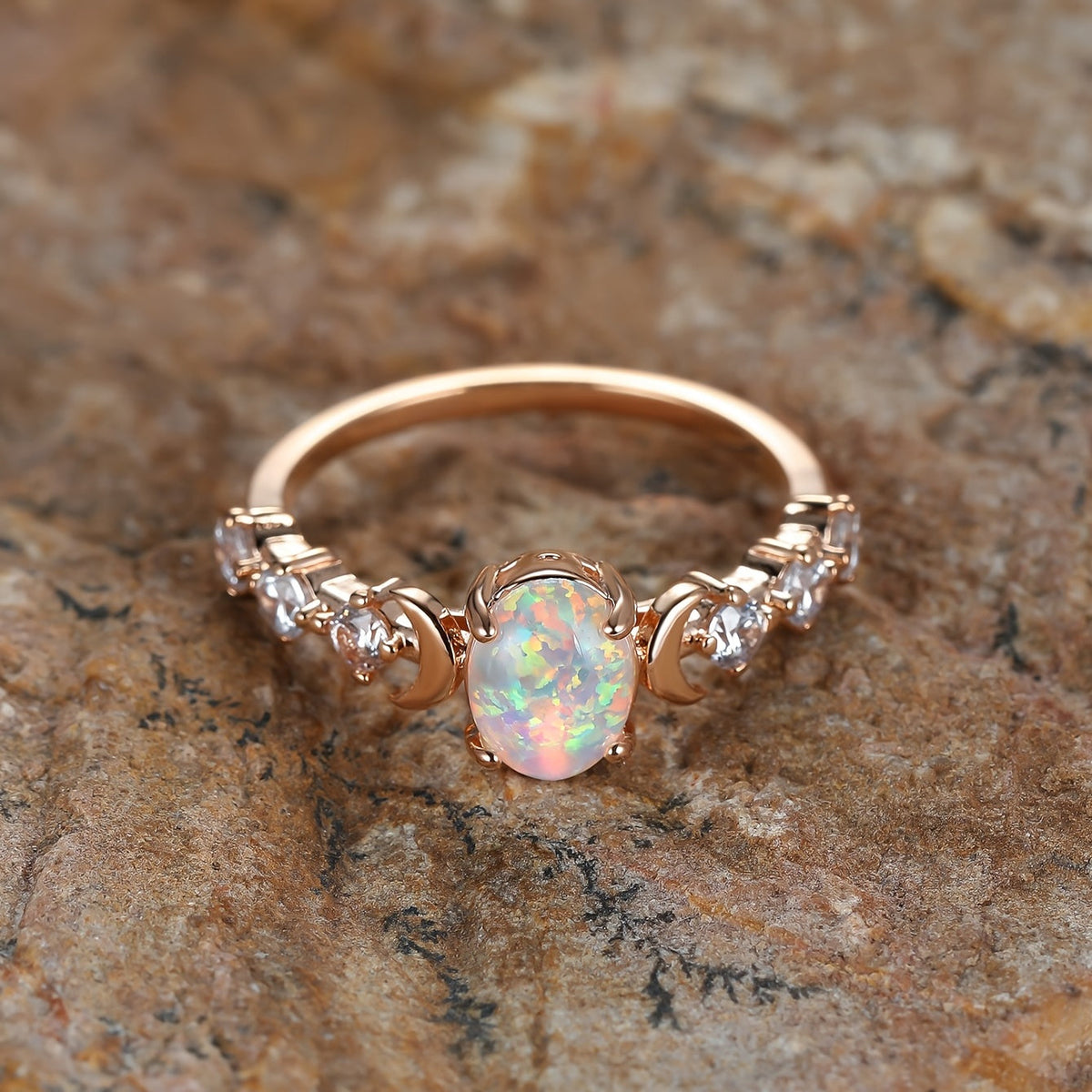 Elegante vergulde ringen met kleine maan en witte regenboog vuuropaal