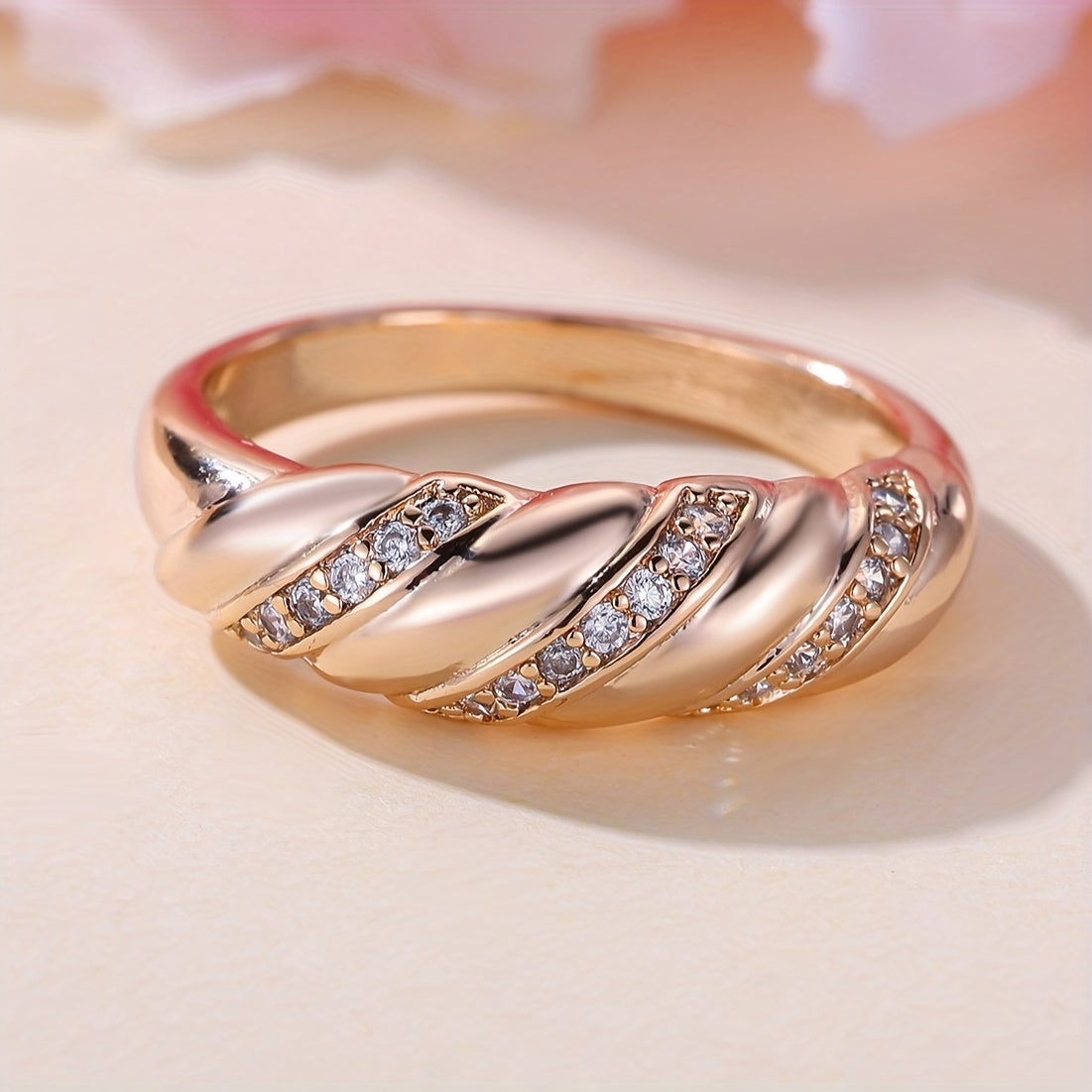 Elegante vergulde ring met ingelegde zirkonia en gedraaid ontwerp