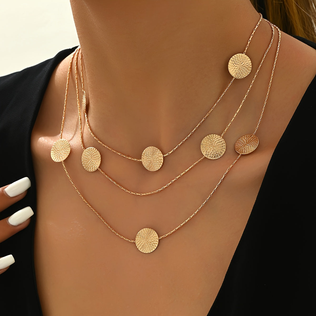 Geometrische goudkleurige gelaagde ketting met spiraalstructuur en meerdere schijven