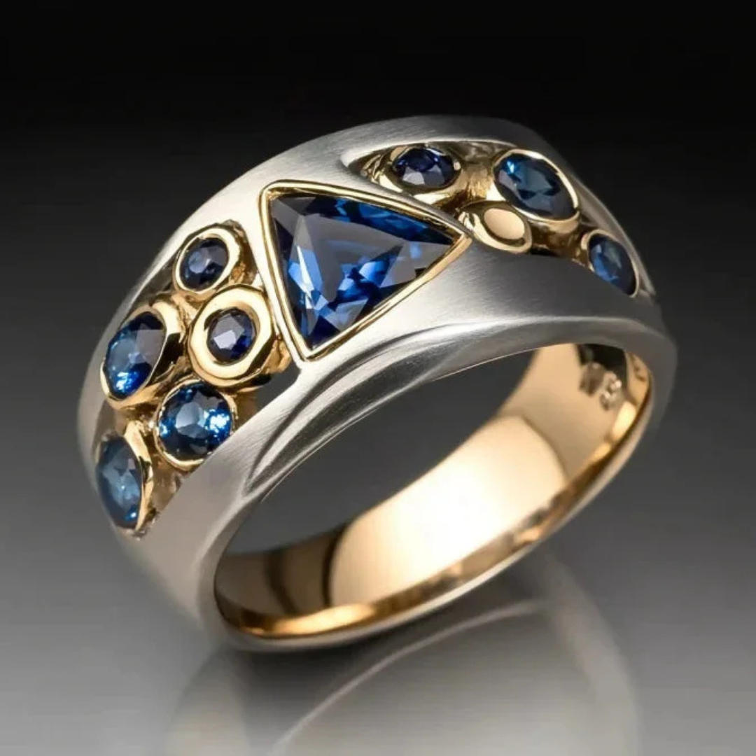 Elegante zilver- en goudkleurige geometrische ring met blauwe zirkonia kristallen