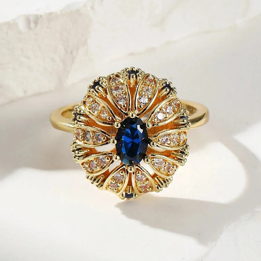 Elegante vergulde ring met zonnebloemontwerp ingelegd met blauwe zirkonia