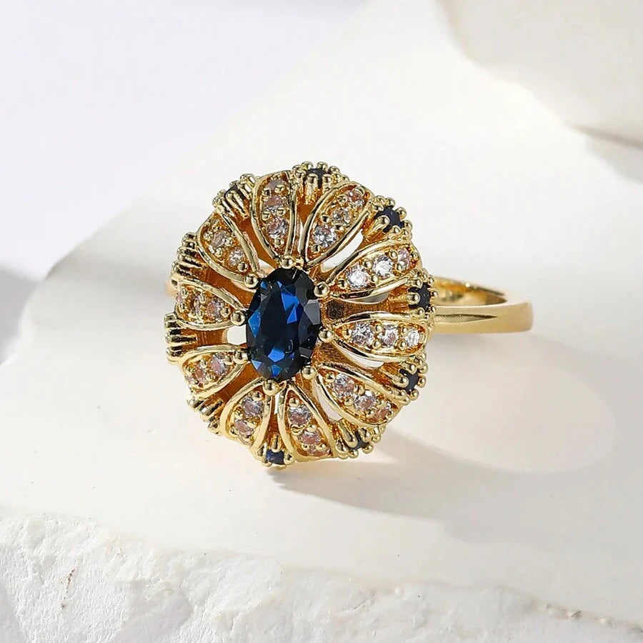 Elegante vergulde ring met zonnebloemontwerp ingelegd met blauwe zirkonia