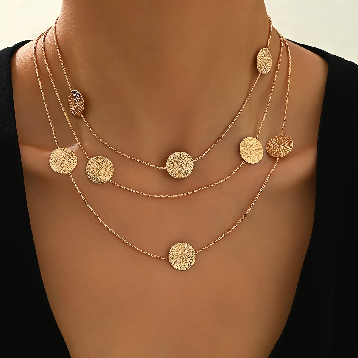 Geometrische goudkleurige gelaagde ketting met spiraalstructuur en meerdere schijven
