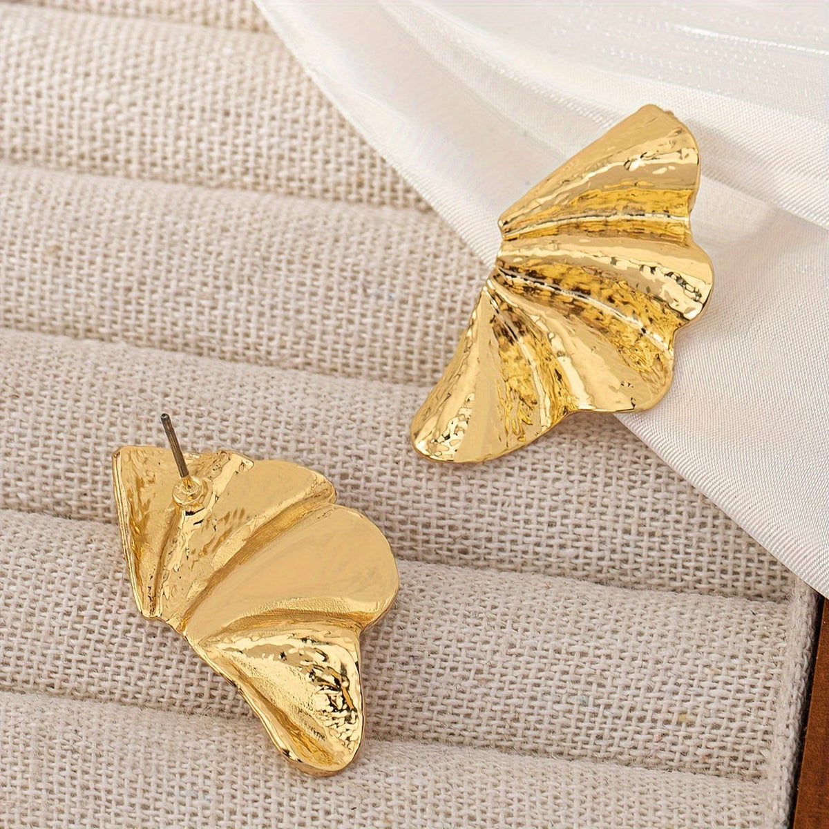 Elegante goudkleurige statement oorknopjes met getextureerde waaier