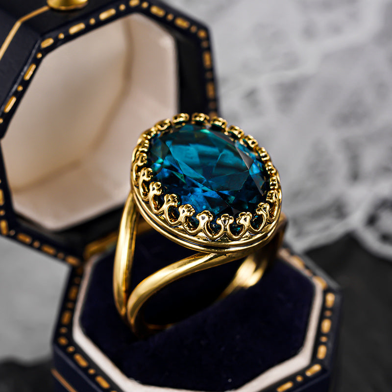 Elegante vergulde ring met ovale blauwe steen