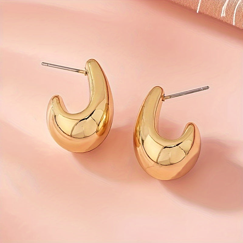 Minimalistische goudkleurige sculpturale C-vormige oorknopjes
