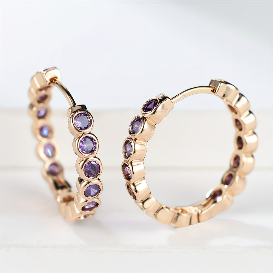 Elegante oorringen met paarse zirkonia kristallen in etnische stijl