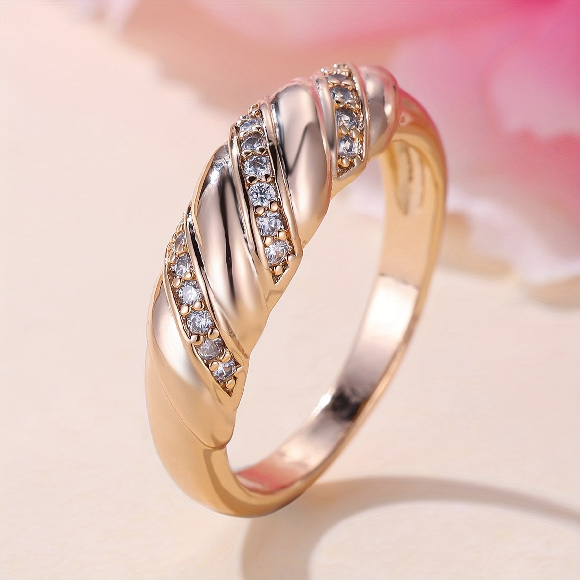 Elegante vergulde ring met ingelegde zirkonia en gedraaid ontwerp