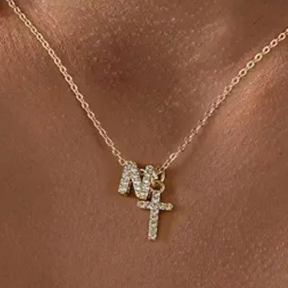 Fijne diamanten ketting met initiaal- en kruishanger
