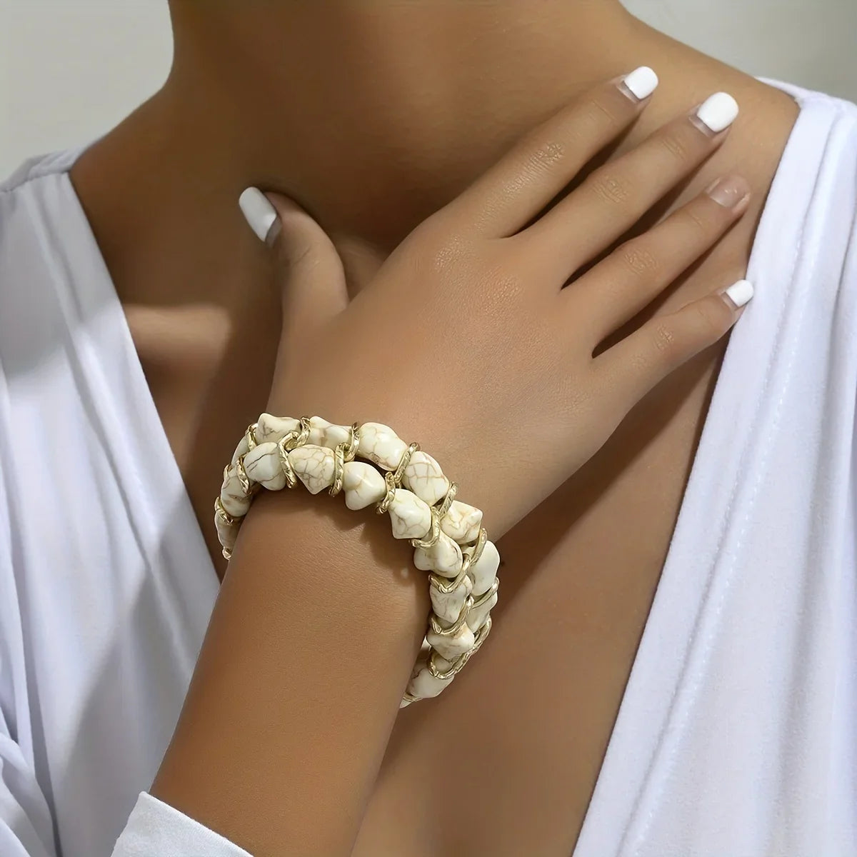 Gevlochten goudkleurige armband met turkooizen steen