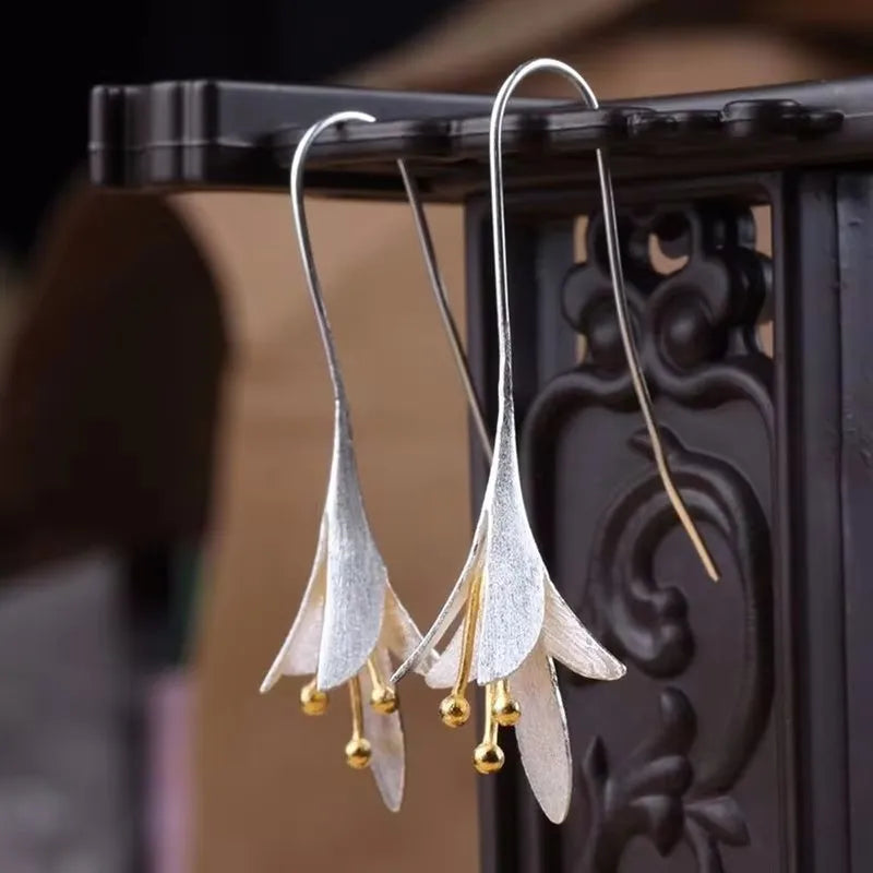 Moderne geborstelde zilverkleurige bloemblad oorhangers