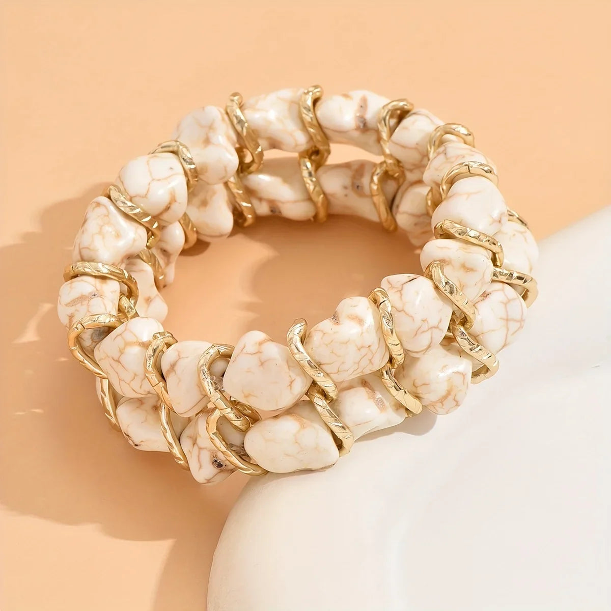 Gevlochten goudkleurige armband met turkooizen steen