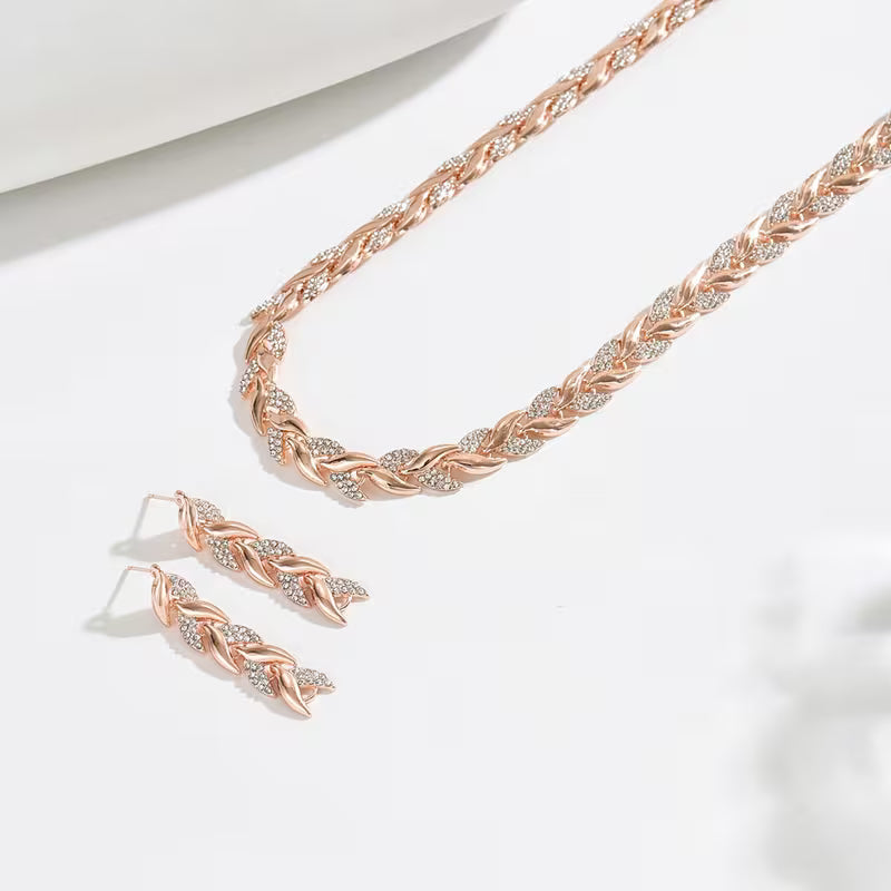 Rosé goudkleurige bladschakel oorbellen- en armbandset