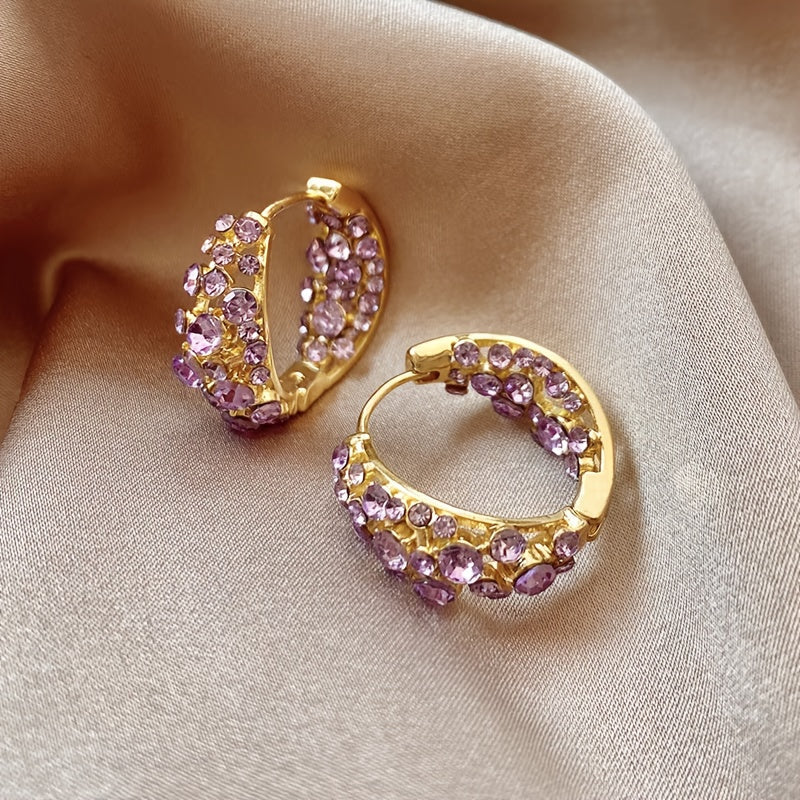 Elegante vergulde oorringen met paars kristal en zirkonia
