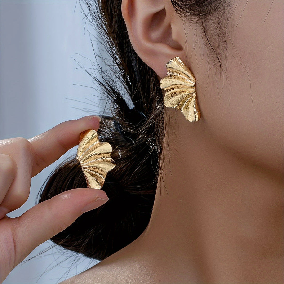 Elegante goudkleurige statement oorknopjes met getextureerde waaier