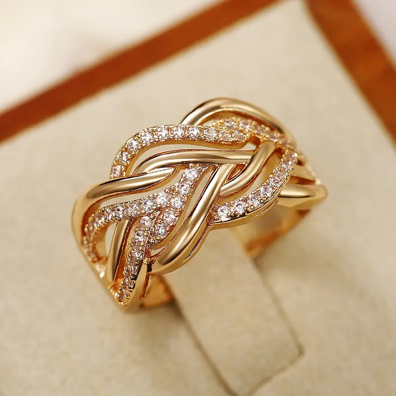 Elegante vergulde ring met verweven diamanten knoop