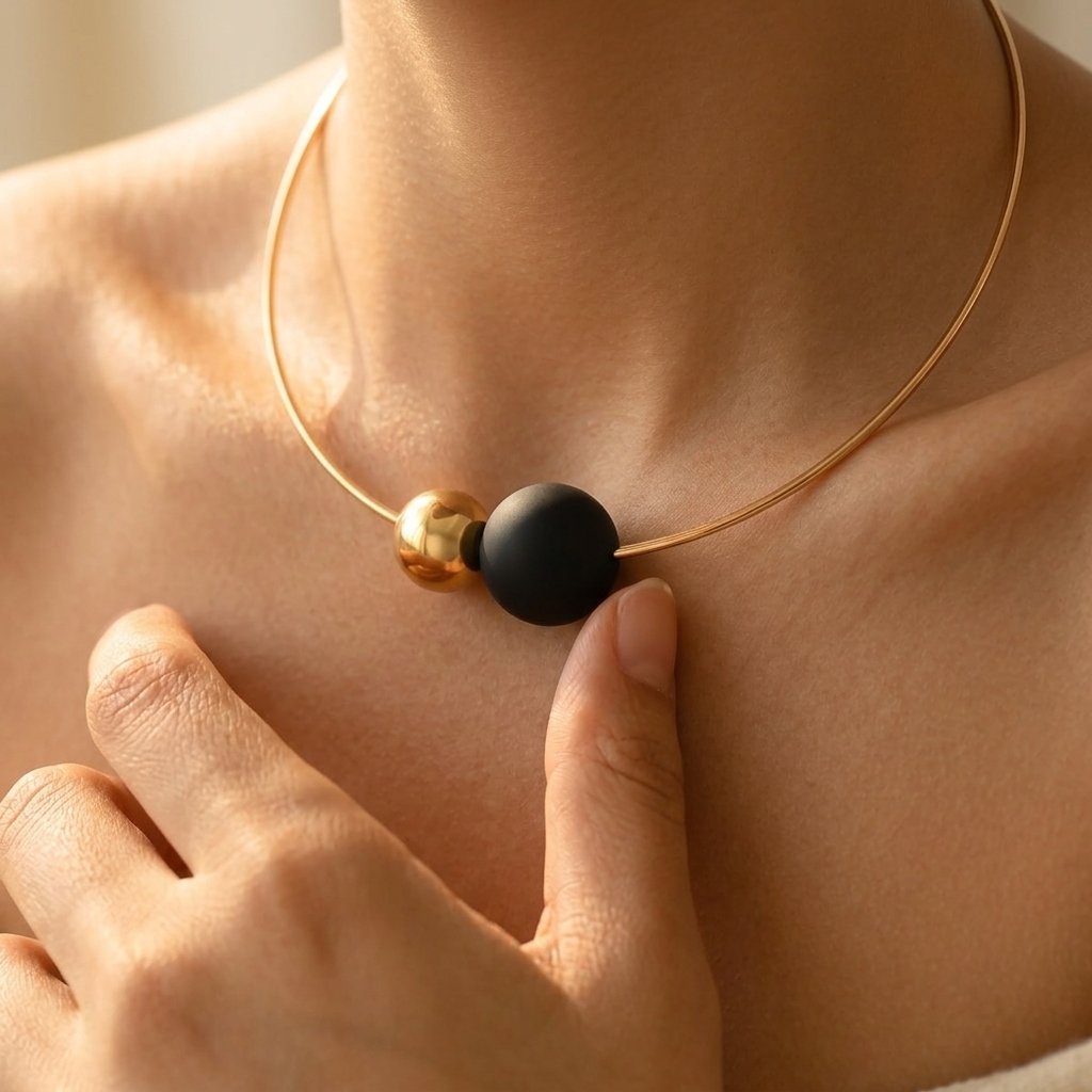 Minimalistische goudkleurige ketting met zwarte ronde bol