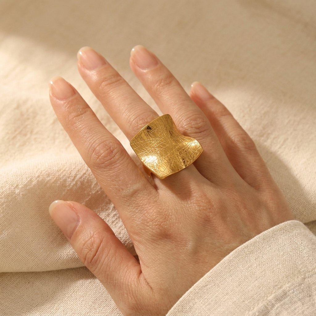 Minimalistische goudkleurige vierkante ring met textuur