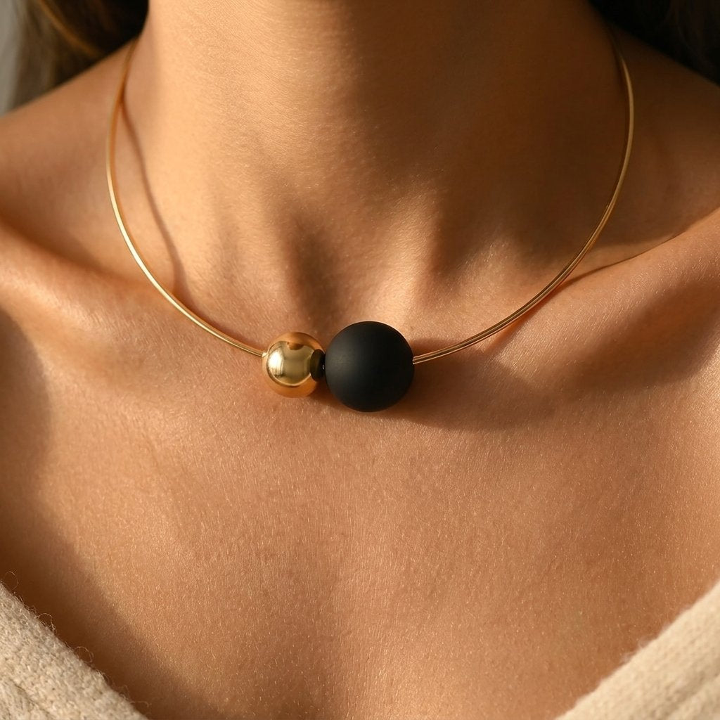 Minimalistische goudkleurige ketting met zwarte ronde bol