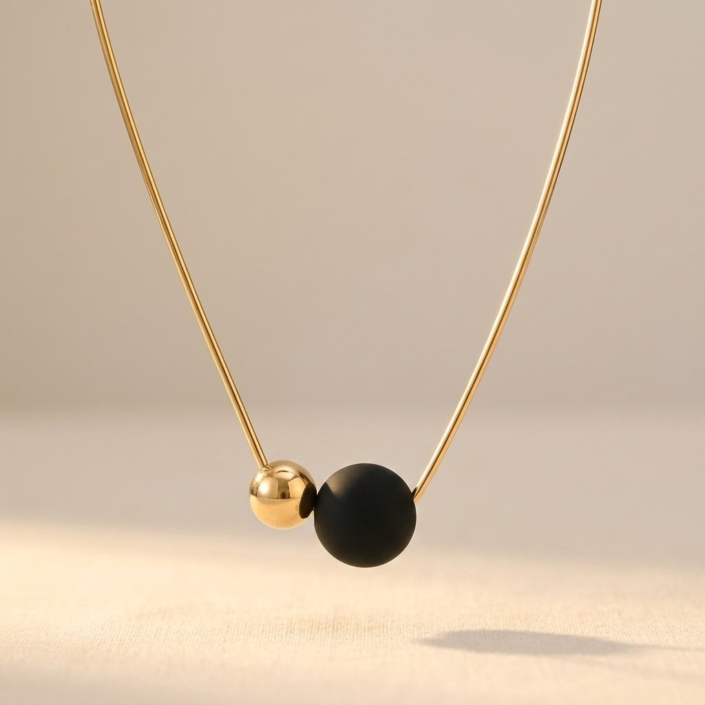 Minimalistische goudkleurige ketting met zwarte ronde bol